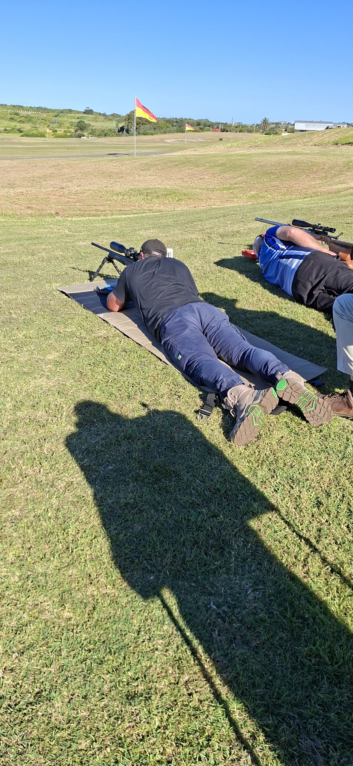 Shooters prone along the mound on a clear day